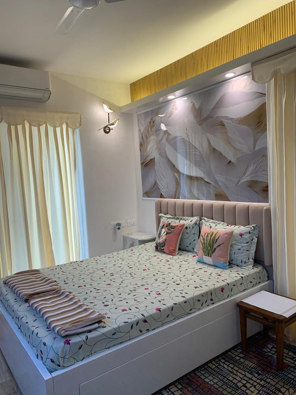 Master bedroom with feather wallpaper headboard, queen bed, and warm lighting