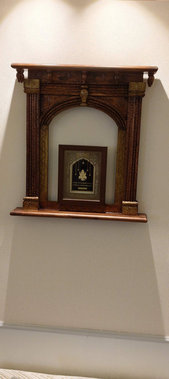 Hand-carved wooden mandir on the wall